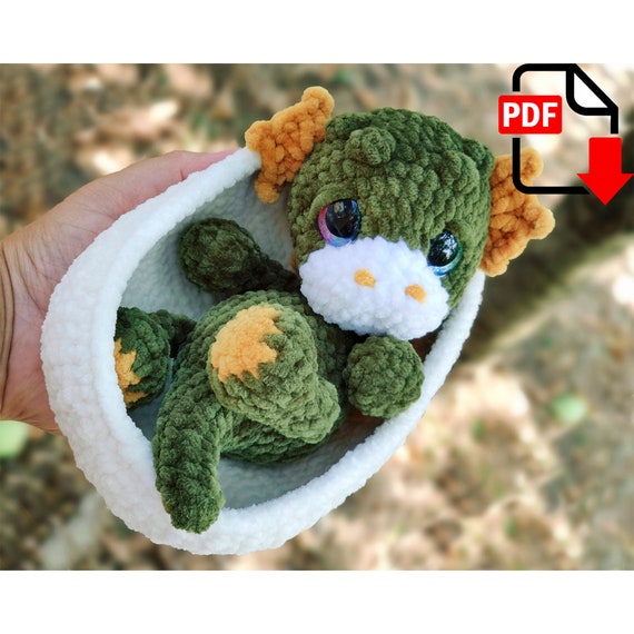 7.90 USDCute plush baby dragon in a shell. This will be a good gift not only for a child, but also for an adult. Give your loved one a soft symbol of 2024 made with your own hands.Language: English and Russian.Please note: this is not a readymade toy. Materials not included.List of recommended materials and tools•Yarn HiMALAYA Dolphin Baby, gauge: 120m/100gr. For a toy you will need one half of a skein main color and 15 or 20 gr of additional yarn color.Yarn colors choice depends on your fantasy.•For the egg shell you will need less than one skein of yarn milk or beige color.•Size 2.75 or 3mm crochet hook.Final size of the toy is about 22 cm tall, depending on how tight you crochet. Egg size is 17x13 cm, 7 cm tall.•Thin acrylic thread matching color to do sculpting.•Toy eyes d. 16 or 20mm.•Toy stuffing.•Wide-eyed needle to do sculpting.•Scissors.•Stitch markers.
