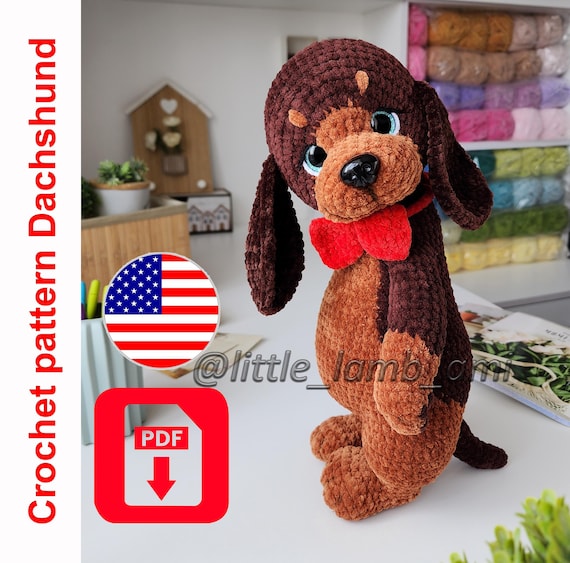 12.20 USDThis crochet dachshund pattern will help you create a plush amigurumi dog with long floppy ears and a classic red bow tie. The finished toy stands upright and has a soft, velvety texture, making it perfect as a nursery decor piece, a handmade gift, or a collectible plush. The pattern is suitable for confident beginners and intermediate crocheters who are comfortable working in the round and assembling details.DIGITAL DOWNLOADThis listing is for a digital PDF crochet pattern only. No physical item will be shipped.The pattern is written in English using US crochet terminology.It is an original design written by a human designer, not AI-generated.All photos in the listing show real finished toys made from this pattern.What’s included- Step-by-step written instructions for the full dachshund- Detailed assembly guidance- Abbreviations (US terms) and recommendations- Clear structure for each body partAll body parts are crocheted separately and joined as you work. The head is attached using a cotter pin joint for mobility, and the ears are sewn on.Finished sizeThe finished dachshund measures approximately 13 inches (33 cm) tall when made with the recommended yarn and hook.The final size may vary depending on your yarn choice, hook size, and personal tension.Materials and tools- Chenille-style yarn (light worsted weight) for the main color, approx. 110-120 g (131 yds / 100 g skein reference)- Additional colors for details- Black yarn for facial accents- 3.5 mm crochet hook (US E/4)- Safety eyes (approx. 18 mm)- Plastic safety nose (approx. 18×24 mm)- Polyester stuffing- Tapestry needle- Stitch marker- Cotter pin joint with two discs for the head- Scissors- Optional dry pastels and a small brush for shadingThis pattern uses US crochet terms and is designed to create a sturdy, freestanding plush dog with a soft, rounded shape.