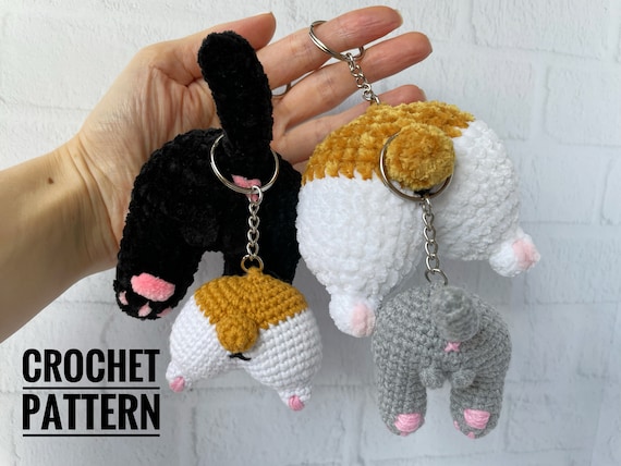4.99 USDKeychain Cat butt and Dog butt, made with your own hands, will be a great and fun gift. This crochet pattern will help you to make a keychain. This keychain would be a great gift for cat and dog lovers.This is NOT THE FINISHED KEYCHAIN! This is DOWNLOADABLE PDF CROCHET PATTERN !This listing is an original pattern (written in English using American terminology) to crochet.This pattern consist of 12 pages for crocheting Cat Butt and Dog butt Keychain in the pdf format.Skills level – intermediate.— The size of the plush keychain is about 8 cm; — The size of the cotton keychain is about 4-5 cm; ____________________________This crochet pattern is easy to follow with step-by-step instructions, photos illustrating the process).It does not contain crochet lessons. You should have basic crochet skills to be able to crochet with the help of this crochet pattern.*****************************************This crochet pattern is available for Instant Download. When your payment is completed you will receive an email with all the information needed to download your file. This email will be sent to the email address connected with your Etsy Account. If you have any problem, please contact me.*********************************You will need Adobe Reader to open this Pattern. Materials and tools for the keychain made with cotton yarnSport weight/4ply yarn YarnArt JEANS or Alize Cotton Gold of any color and some pink colorSewing needle Hook size 2.25 mm by CloverStuffing toys materialKeychain fastenerMaterials and tools for the keychain make with plush yarnSuper Bulky/Super Chunky/14ply velvet yarn HIMALAYA DOLPHIN BABY of any color and some pink colorSewing needle Hook size 3 mm by CloverStuffing toys materialKeychain fastenerAbbreviations: MR – magic ring sc – single crochet inc – increase dec – decrease sl st – slip stitch 5-dc Bobble st – crochet 5 dc in one stitch with a common top(….) * n – repeat instruction in brackets N times (…) – number of loops in a row